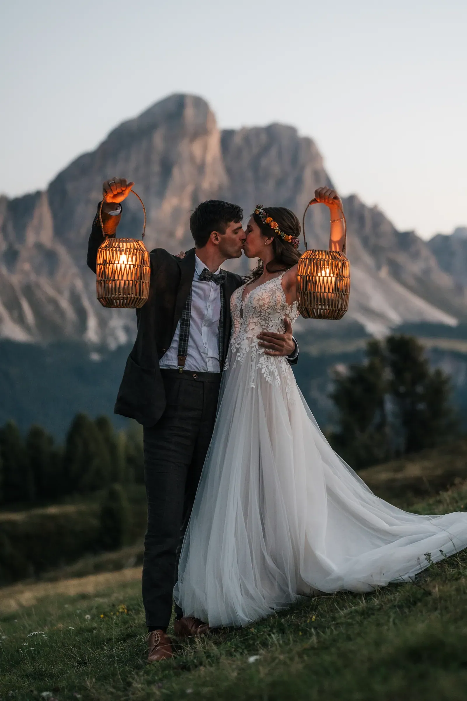 Brautpaar mit leuchtenden Laternen im Abendlicht vor dem Dolomitengipfel