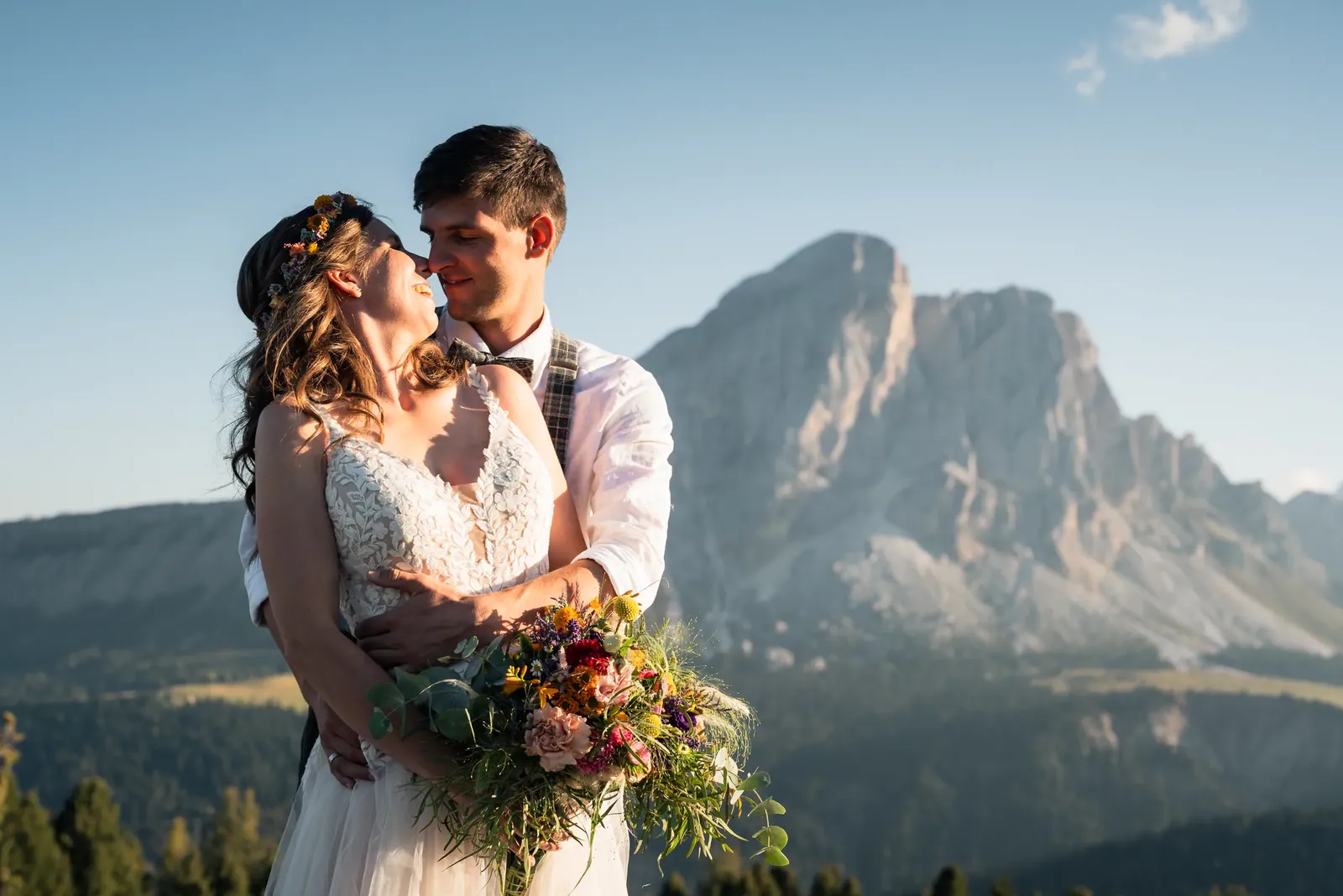 Brautpaar mit Wildblumenstrauß vor dem Dolomitengipfel
