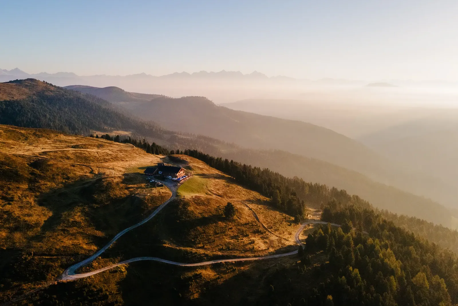 Drohnenfoto der Almwiesen bei Sonnenaufgang über dem Nebel