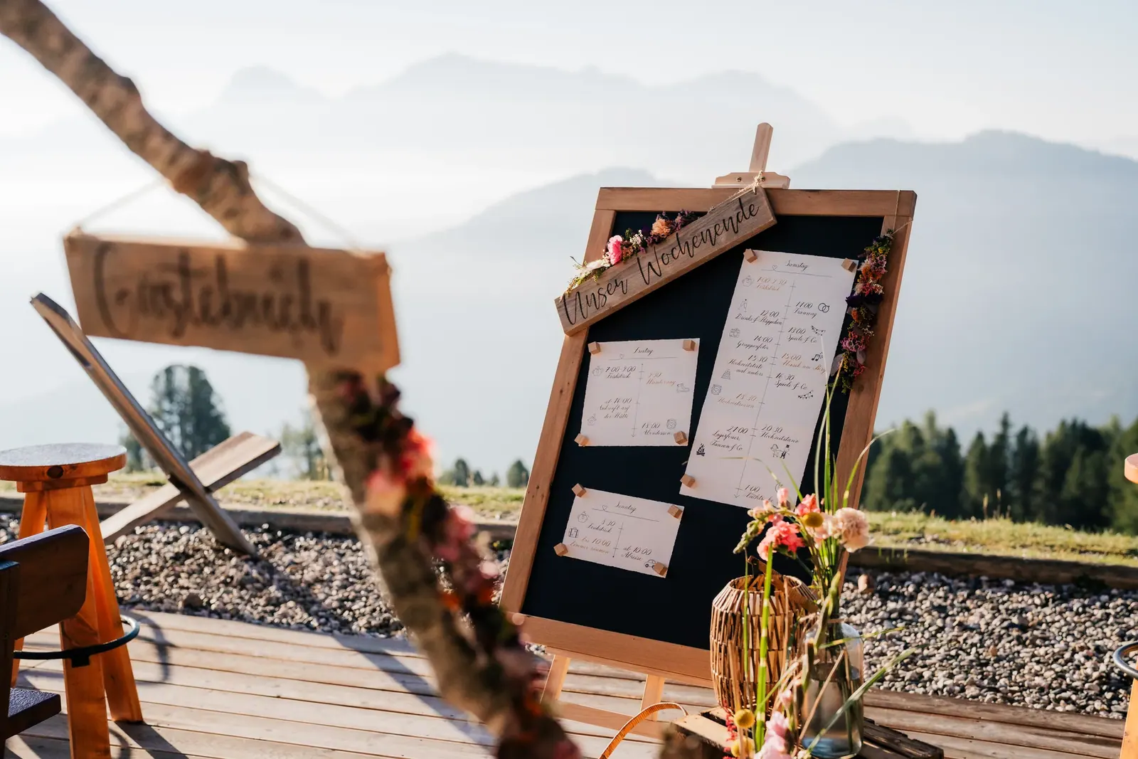 Gästebuch und Sitzplan mit Wildblumen auf der Terrasse der Berghütte